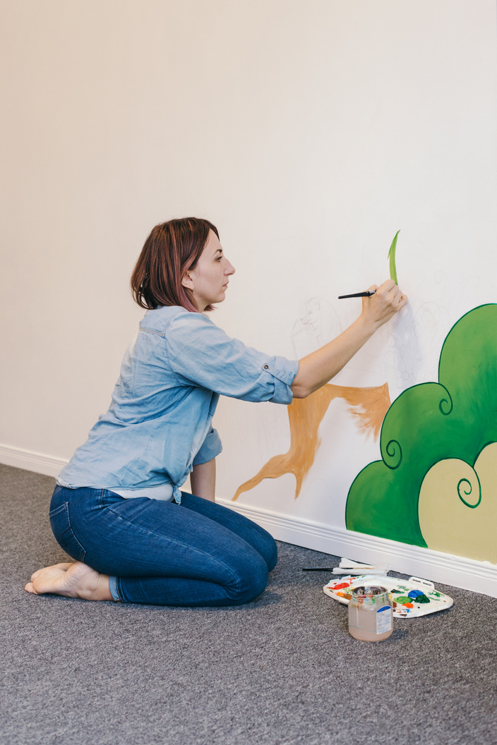 Woman Painting a Wall Mural